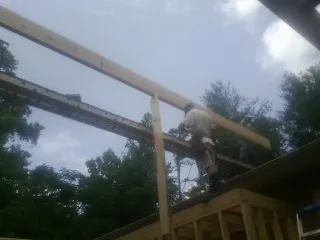 Carpenter setting a ridge beam over a new addition frame — Ice Dam Removal by Roofing Brothers in Wrightsville
