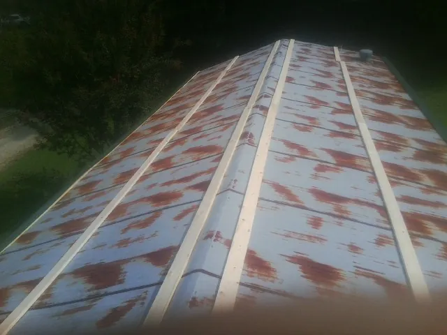 Rusted metal roof panels with new wood purlins before replacement — Storm Damage Roof Repair in Wrightsville by Roofing Brothers
